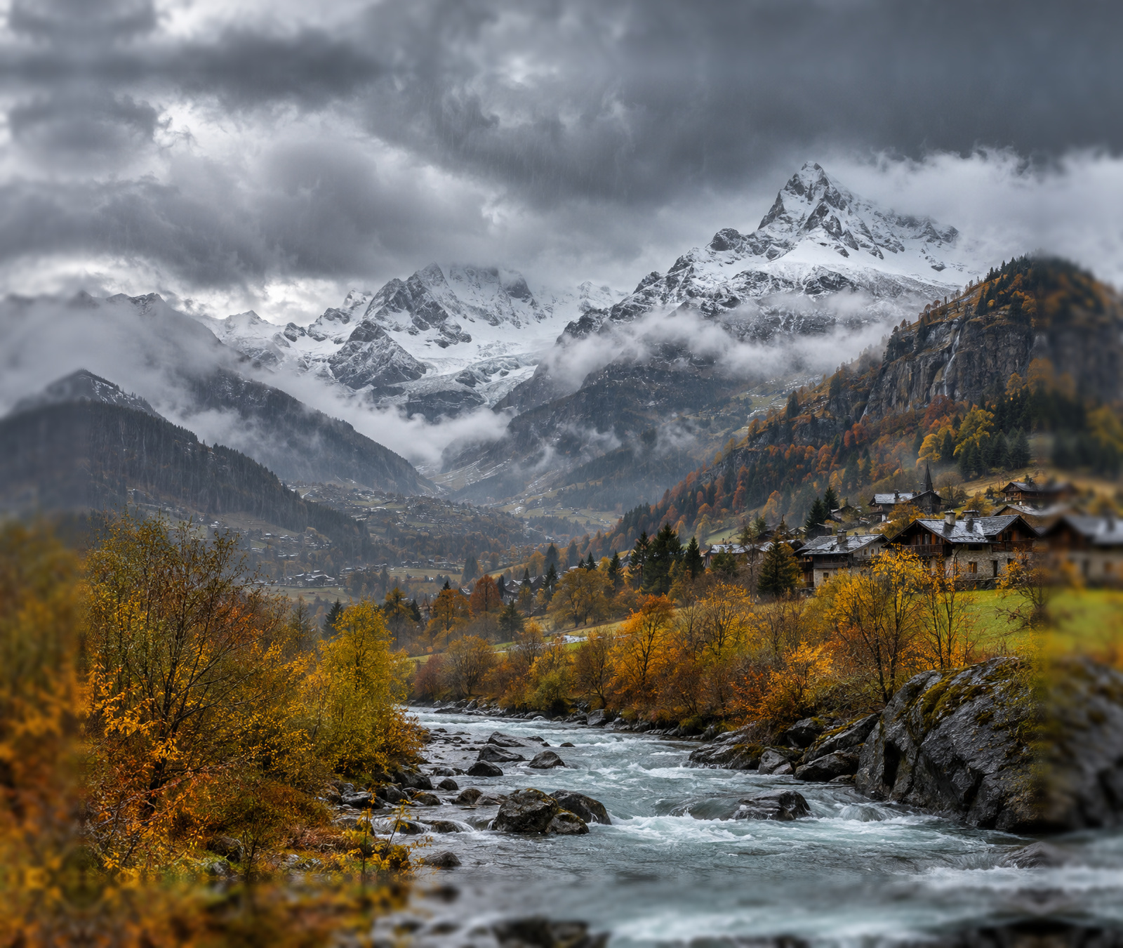 Herbstliche Schweizer Alpen unter dichten Kaltfrontwolken mit Regen und frischem Schnee in den Hochlagen.